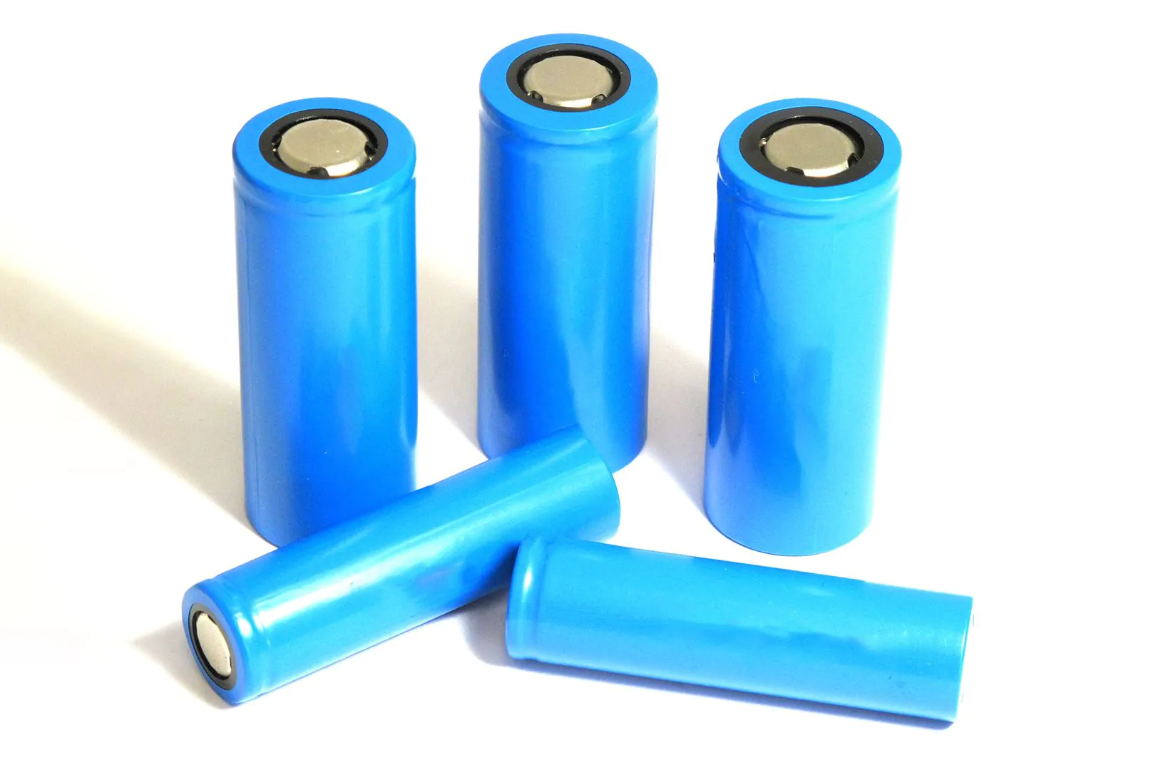 Vier blauwe cilindrische lithium-ijzerfosfaatcellen op een witte ondergrond